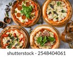 Top view of various neapolitan pizzas on grey stone table