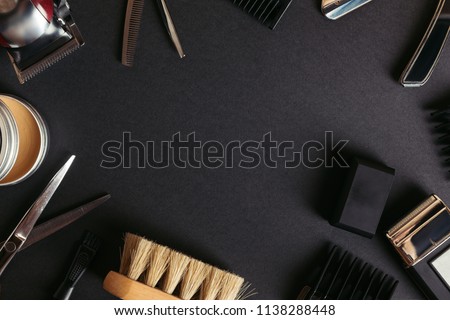 top view of various professional barber tools on black background