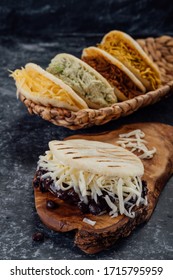 Top view of various types of typical Venezuelan arepas in a woven basket