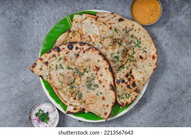 A Top View Of Veg Stuffed Paratha With Gravy And Curd Raita