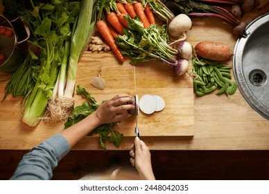 Top view, vegetables and chopping board with hands, cutting and prepare healthy meal. Hand, knife or kitchen utensils with vegan diet, nutrition and organic ingredients with vegetarian dinner at home - Powered by Shutterstock