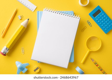 Top view of vibrant school supplies including notebook, pencil, calculator, ruler, and paper clips on a bright yellow background - Powered by Shutterstock