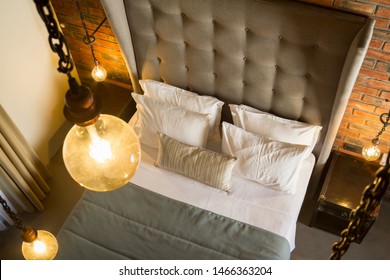 Top view vintage design hotel bedroom with old decoration, wooden window, light blue bed sheets, white pillows, runner, concrete floor paving and brick wall. - Powered by Shutterstock