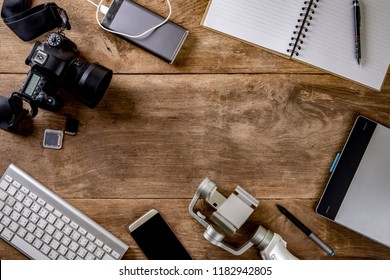 Top view vintage style of photographer consisting on a cameras, a keyboard, a smart phone, notebook on a wooden desk background - Powered by Shutterstock