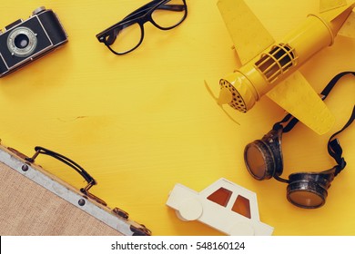 Top View Of Vintage Yellow Toy Plane, Old Photo Camera, Pilot Glasses And Suitcase