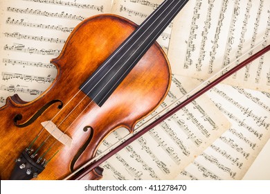 Top view of violin and bow on musical score