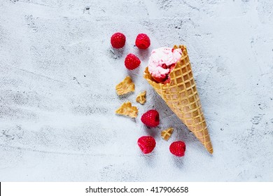 Top View Of Waffle Cone With Raspberry Ice Cream Over Concrete Textured Background.