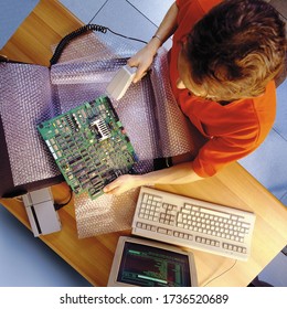 Top view of a warehouse worker coding the computer components to be shipped with a bar reader. Photo from 1990