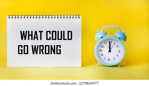 Top view of what can go wrong, text on notepad and yellow background with clock. Business concept.