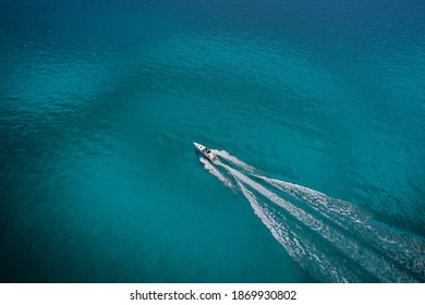 Top View Of A White Boat Sailing To The Blue Sea. Drone View Of A Boat. Aerial View Luxury Motor Boat. Drone View Of A Boat  The Turquoise Clear Waters.