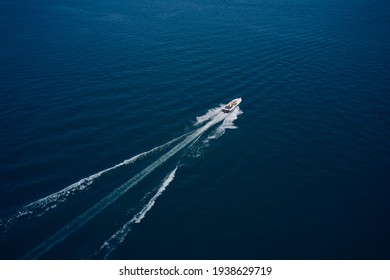 Top View Of A White Boat Sailing To The Blue Sea. Large Speed Boat Moving At High Speed Side View