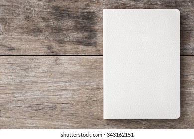 Top view of white book on old wooden plank background