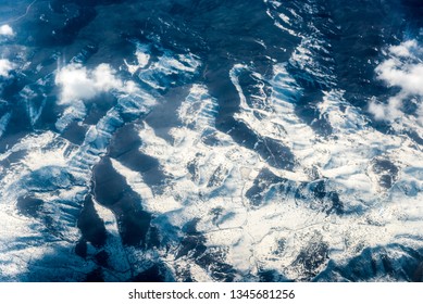 Top view of white clouds between which you can see high mountains. Horizontal frame