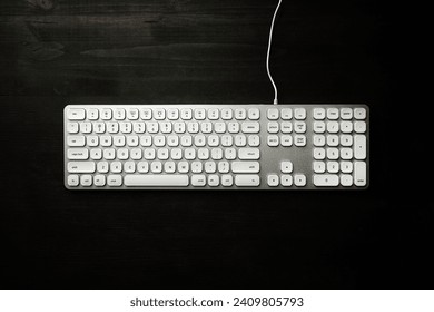 Top view of white computer keyboard on black office desk, copy space included