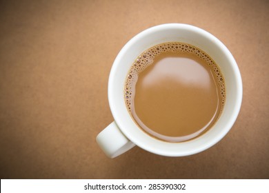 Top view of white cup of coffee on wooden table