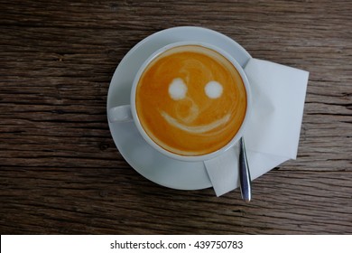 Top View White Cup Of Hot Latte Art Coffee On Wooden Background. Smiley Coffee