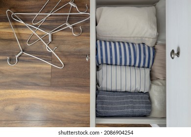 Top View Of White Dresser And One Opened Drawer Of It Against Wooden Floor.Empty Floor.Folded Casual Shirts.Concept Of Tidy Wardrobe