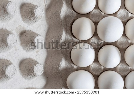 Top view of white eggs on a cardboard egg tray. Closeup