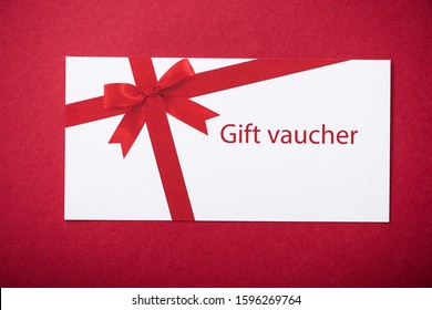 Top View Of White Gift Voucher On Red Surface