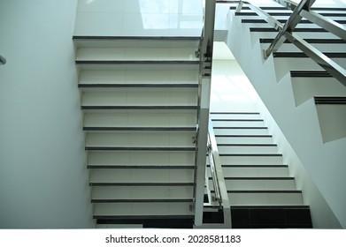 Top View Of White Lime Stairs With Black Anti-slip Edge Stairs Inside Multi-storey Buildings Have Stainless Steel Railings For Walking Up Or Down Between Floors.