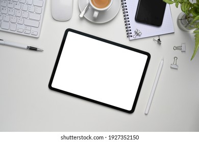 Top View Of White Office Desk With Digital Tablet, Smart Phone And Office Supplies.