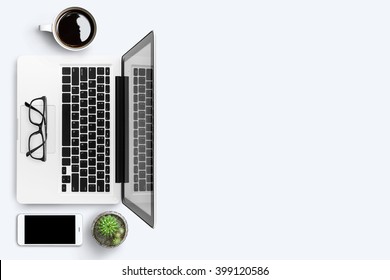 Top view of white office desk with laptop, smartphone, cup of coffee and supplies. Top view with copy space. - Shutterstock ID 399120586