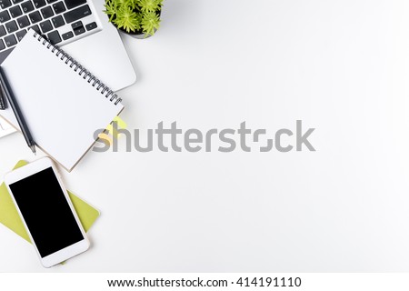 Top view of white office table with laptop, smartphone and supplies. Top view with copy space.