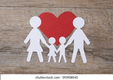 Top View Of White Paper Chain Family On Red Shape Heart. Family In Love. Family Care And Unity Concept.