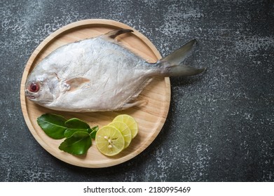 Top View White Pomfret Raw Silver Pomfret Fish In Wooden Plate On Needle Colored Background