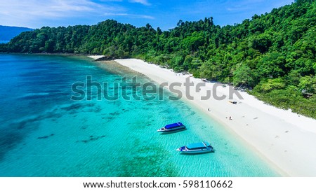 Top view of white sand beach with rock and power speed boat on the beach, Ta Fook island, south of Myanmar, Top view from drone