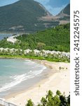 Top view white sandy beach with row houses, luxury vacation homes, ocean view villas surrounding by coconut palm trees, mountain, lush green tropical forest background Hon Tre, Nha Trang. Vietnam