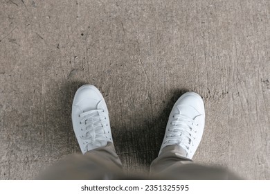 Top view of the White shoe on cement floor. White sneakers for men. Bird eye view of white fashion shoes on the floor. Cloth shoes in Muji style for men. - Powered by Shutterstock