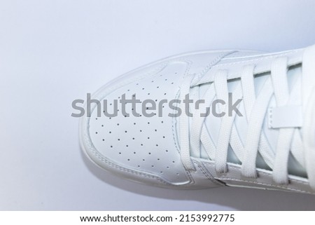 Top view of a white sneaker on a white background - white shoe with white laces