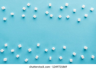 top view of white sugar cubes with copy space on blue background - Powered by Shutterstock