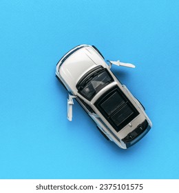 Top view of a white SUV with open doors on a blue background. The concept of auto mania. Flat lay. - Powered by Shutterstock