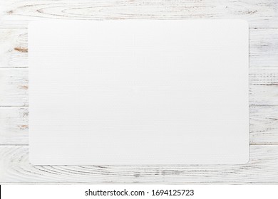 Top view of white table napkin on wooden background. Place mat with empty space for your design.