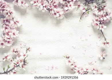 A top view of a White wood textured background decorated with almond rose flowers