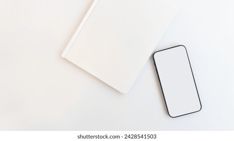 Top view: white workspace background with smartphone white screen mockup, notebook, , potted plant and copy space. top view, flat lay