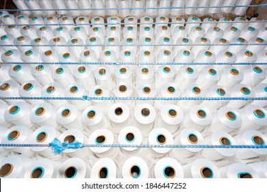 Top View Of A Lot Of White Yarn Spools In A Textile Factory. White Yarn Spools In A Clothing Factory.