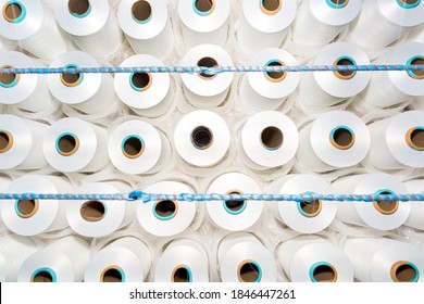 Top View Of A Lot Of White Yarn Spools In A Textile Factory. White Yarn Spools In A Clothing Factory.