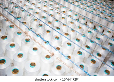 Top View Of A Lot Of White Yarn Spools In A Textile Factory. White Yarn Spools In A Clothing Factory.