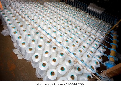 Top View Of A Lot Of White Yarn Spools In A Textile Factory. White Yarn Spools In A Clothing Factory.