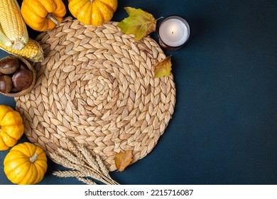 Top View Of Wicker Place Mat, Pumpkins, Harvest, Corn, Chestnut, Autumn Leaves, Candle On Dark Table. Restaurant Menu. Cozy Hygge Table Setting On Autumn Background. Copy Space