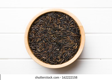 Top View Of Wild Rice In Wooden Bowl On White Table