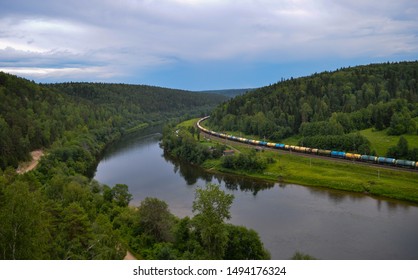 Top view of a winding river in the forest along which the train goes