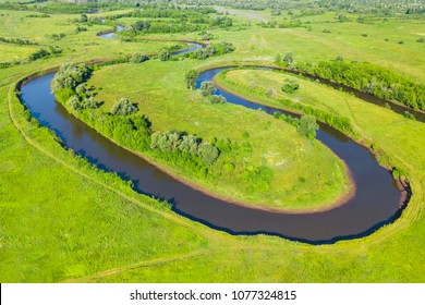 Top view of a winding river in a green valley