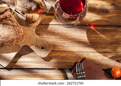 Top View Of Wine And Bread On Wooden Table With Fork And Knife