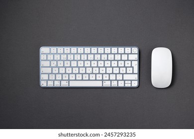 Top view of wireless keyboard and mouse on dark gray work desk - Powered by Shutterstock