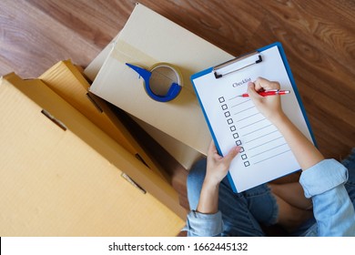 Top view of woman checking goods package or packing before delivery or shipping to customers as order in shopping online, prepare relocate and move to new house with checklist and order list.   - Powered by Shutterstock