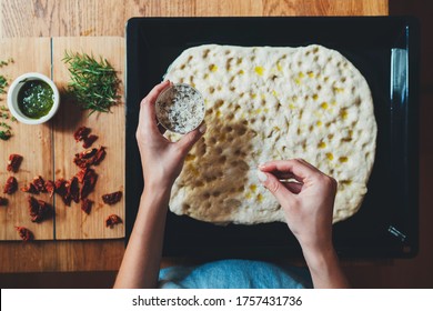 Top View Of Woman Cooking Italian Focaccia Bread Adds Ingredients To The Dough, Italian Focaccia With Rosemary And Sun-dried Tomatoes, Homemade Healthy Food Concept, Cooking Class Online